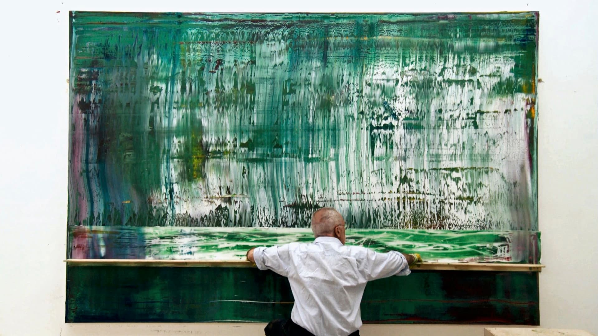 Picture of Gerhard Richter while he is painting a canvas in different shades of green